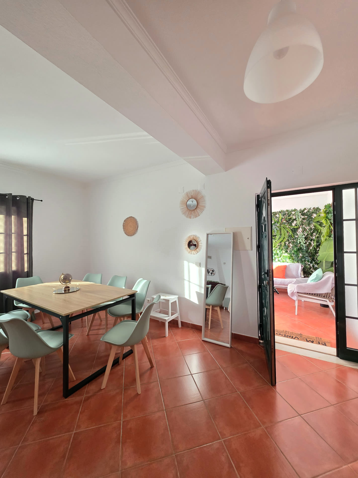 Sala de refeições da Breeze House Almograve com mesa para oito pessoas e saída para o pátio
